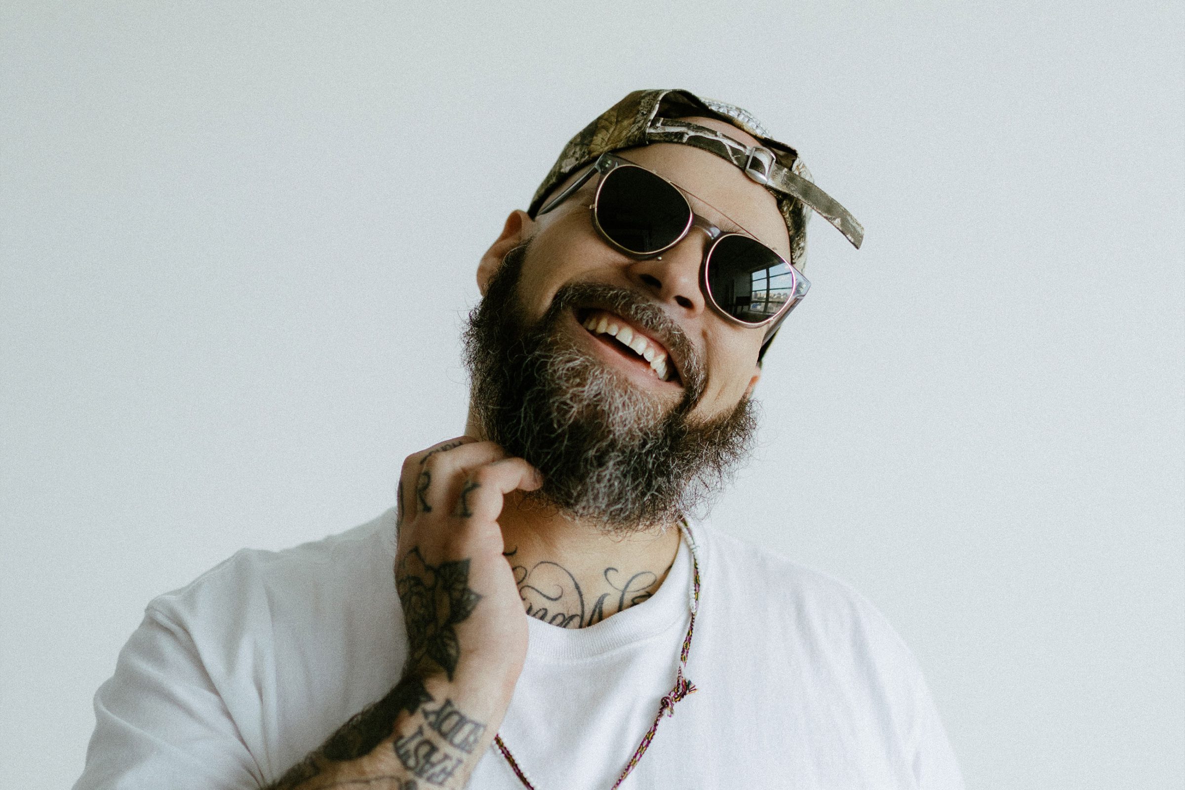 Edrian laughing in sunglasses and backwards cap